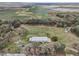 Expansive aerial view of a country estate surrounded by trees and open fields near a solar farm at 2040 Underwood Ln, Zephyrhills, FL 33540