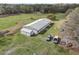 Aerial view of single Gathering residence with sheds, green space, and multiple vehicles parked on property at 2040 Underwood Ln, Zephyrhills, FL 33540