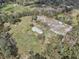 Areal view of home with metal roof, buildings, outbuildings and spacious land surrounded by mature trees at 2040 Underwood Ln, Zephyrhills, FL 33540