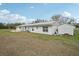 Side view of a barn with white siding and a metal roof at 2040 Underwood Ln, Zephyrhills, FL 33540