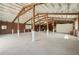 Spacious barn interior with high ceilings, wood beams and concrete floors at 2040 Underwood Ln, Zephyrhills, FL 33540