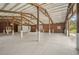 Interior of barn featuring chandeliers, concrete flooring and wood columns at 2040 Underwood Ln, Zephyrhills, FL 33540