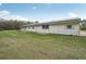 White ranch style home with a metal roof and a well-manicured green lawn, ideal for country living at 2040 Underwood Ln, Zephyrhills, FL 33540