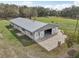 Aerial view of this single-story home with large metal building, patio, and ample green space at 2040 Underwood Ln, Zephyrhills, FL 33540
