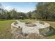 Beautiful brick fire pit and sitting area with walkway and mature trees, perfect for outdoor gatherings at 2040 Underwood Ln, Zephyrhills, FL 33540