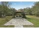A beautiful outdoor gazebo sits on a paver patio surrounded by trees and other lush landscaping at 2040 Underwood Ln, Zephyrhills, FL 33540