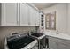 Modern laundry room with gray cabinets, laundry sink, and front load washer and dryer at 2575 Claymore St, Odessa, FL 33556