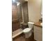 Bathroom showcasing a tiled walk-in shower, toilet, and granite countertop sink at 2765 Countryside Blvd # 106, Clearwater, FL 33761