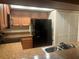 Galley kitchen with black appliances, wood cabinets, and granite countertops at 2765 Countryside Blvd # 106, Clearwater, FL 33761