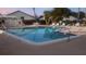 Community pool surrounded by lounging chairs, tables, and shaded umbrellas at 2765 Countryside Blvd # 106, Clearwater, FL 33761