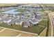 Aerial view of homes in a neighborhood with a lake, landscaping, and roadways at 2839 Gumbo Limbo Dr, Wimauma, FL 33598