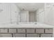 Bright bathroom featuring double vanity with marble countertop and grey cabinets and large mirror at 2839 Gumbo Limbo Dr, Wimauma, FL 33598