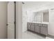 Bright bathroom featuring double vanity with marble countertop and grey cabinets and tile floor at 2839 Gumbo Limbo Dr, Wimauma, FL 33598
