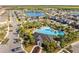 Aerial view of a resort-style community pool and recreational area with palm trees and a playground at 2839 Gumbo Limbo Dr, Wimauma, FL 33598