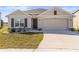 Inviting single-story home with a two-car garage, manicured lawn, and charming exterior at 2839 Gumbo Limbo Dr, Wimauma, FL 33598