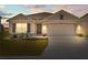 Charming home featuring a two-car garage, well-maintained lawn, and inviting front entrance at 2839 Gumbo Limbo Dr, Wimauma, FL 33598