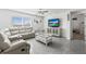 Living room featuring a white leather sectional sofa, modern ceiling fan, and tile flooring at 2839 Gumbo Limbo Dr, Wimauma, FL 33598