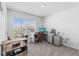 Bright home office featuring a modern desk setup and a large window with neighborhood views at 2839 Gumbo Limbo Dr, Wimauma, FL 33598
