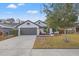 Charming single-story home featuring an attached two-car garage and fresh landscaping at 3038 Longbrooke Way, Clearwater, FL 33760