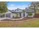 Charming one-story home with a beautifully landscaped front yard, fresh mulch, and healthy plants at 3038 Longbrooke Way, Clearwater, FL 33760