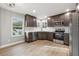 Bright kitchen featuring stainless steel appliances, dark cabinets, and hardwood floors at 3038 Longbrooke Way, Clearwater, FL 33760
