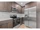 Kitchen features stainless steel appliances, dark cabinets, modern fixtures and white subway tile backsplash at 3038 Longbrooke Way, Clearwater, FL 33760