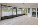Enclosed lanai with tile flooring, screens, and view of fenced backyard at 3038 Longbrooke Way, Clearwater, FL 33760