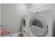 White washer and dryer set with wire shelving above in the laundry area at 3038 Longbrooke Way, Clearwater, FL 33760