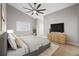 Bright main bedroom with a ceiling fan, large window, and a dresser at 3038 Longbrooke Way, Clearwater, FL 33760
