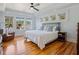 Light-filled bedroom with hardwood floors, a ceiling fan, and a comfortable bed with decorative pillows at 445 13Th Ne Ave, St Petersburg, FL 33701