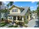 Charming two-story yellow home with a welcoming front porch and lush, tropical landscaping in a desirable neighborhood at 445 13Th Ne Ave, St Petersburg, FL 33701