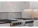 Close up of a stainless steel gas range stove with gray tile backsplash and black countertops in the kitchen at 445 13Th Ne Ave, St Petersburg, FL 33701