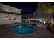 Backyard pool with a spa featuring lush landscaping and nighttime illumination at 445 13Th Ne Ave, St Petersburg, FL 33701