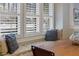 Close up of a window seat nook with decorative pillows, gray upholstery, and shuttered windows at 445 13Th Ne Ave, St Petersburg, FL 33701