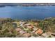 An aerial view of a home close to a lake with dock access amid trees and green surroundings at 4564 Juniper Dr, Palm Harbor, FL 34685