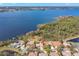 Elevated angle of a home near a lake featuring dock access and green, wooded surroundings at 4564 Juniper Dr, Palm Harbor, FL 34685