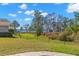Spacious backyard featuring a well-manicured lawn and serene views of the adjacent lake at 4564 Juniper Dr, Palm Harbor, FL 34685