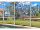 A screened-in pool offers serene backyard views of lush greenery and a tranquil lake at 4564 Juniper Dr, Palm Harbor, FL 34685