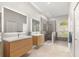 Modern bathroom with dual floating vanities, a glass-enclosed shower, and a window for natural light at 4564 Juniper Dr, Palm Harbor, FL 34685