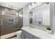 Modern bathroom with a marble countertop sink, gray cabinetry, and a glass-enclosed shower with tiled walls at 4564 Juniper Dr, Palm Harbor, FL 34685
