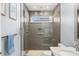 Modern bathroom with a marble countertop sink, gray cabinetry, and a glass-enclosed shower with tiled walls at 4564 Juniper Dr, Palm Harbor, FL 34685