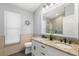 Bathroom featuring double sinks with granite countertops, a decorative mirror, and neutral tile at 4564 Juniper Dr, Palm Harbor, FL 34685