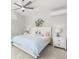 Bedroom features a ceiling fan, light gray walls, carpeted floors, and a bed with bedside tables and lamps at 4564 Juniper Dr, Palm Harbor, FL 34685