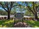 Entrance to Lansbrook Commons with sign amid manicured landscaping and mature trees at 4564 Juniper Dr, Palm Harbor, FL 34685