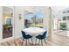 Dining area featuring a white table and blue chairs with a view of the screened-in pool at 4564 Juniper Dr, Palm Harbor, FL 34685