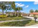 Beautiful home with lush landscaping, palm trees, tile roof, arched entryway and spacious three-car garage at 4564 Juniper Dr, Palm Harbor, FL 34685