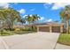 Beautiful home with lush landscaping, palm trees, tile roof, arched entryway and spacious three-car garage at 4564 Juniper Dr, Palm Harbor, FL 34685