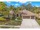 Stunning home exterior featuring a well-manicured lawn, mature trees, and a tile roof at 4564 Juniper Dr, Palm Harbor, FL 34685