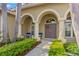 Inviting front entrance featuring a double door, arched entryway, columns and lush landscaping at 4564 Juniper Dr, Palm Harbor, FL 34685