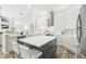 Modern kitchen with a large island, stainless steel appliances, white cabinets, and wood-look flooring at 4564 Juniper Dr, Palm Harbor, FL 34685